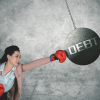 Woman punching a ball labeled Debt